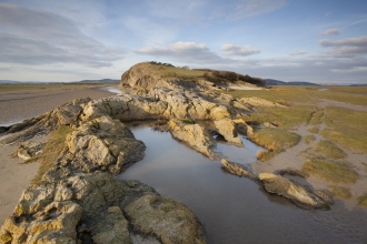image of Limestone outcrop on edge of saltmarsh and mudflats at Humphrey Head onMorecambe Bay in Cumbria