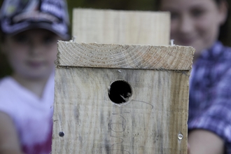 two people holding a homemade bird box they have built credit Peter Cairns/2020VISION