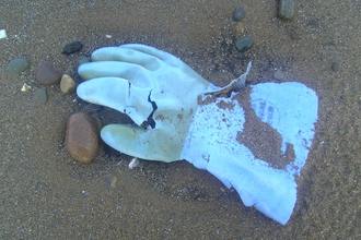 Blue industrial rubber glove washed in on the tide