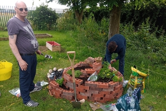 Image of two men creating spiral herb garden at Melbourne View