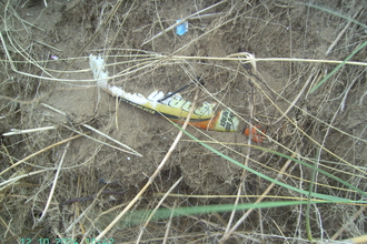 Half buried bottle in the sand dunes