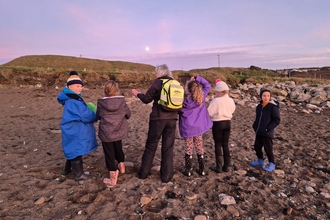 Wildlife Club Rosie with children on a beach