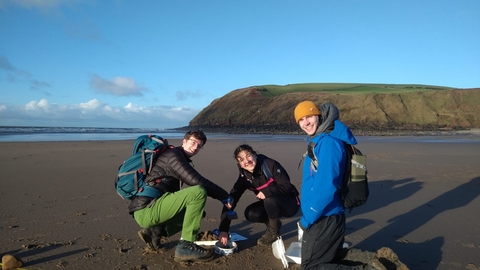 Image of three people carrying out survey on beach