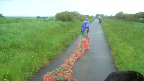 Large fishing net being dragged away for disposal