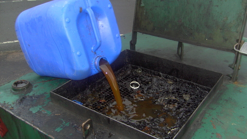 Decanting old oil from a canister found on the beach at the local recycling centre