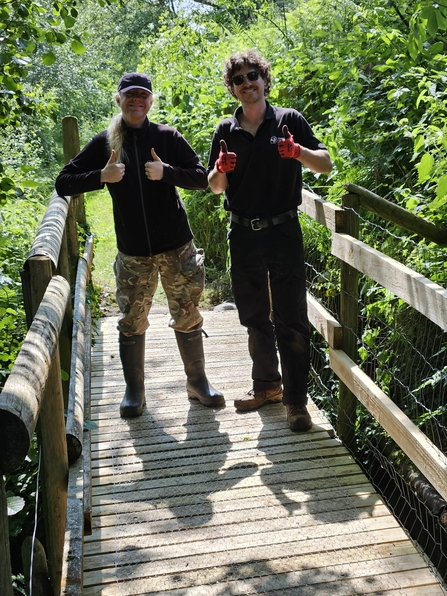 Two student placements standing on a bridge with their thumbs up © Thomas Langmead