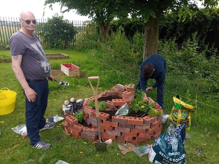 Image of two men creating spiral herb garden at Melbourne View